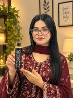 Woman in maroon holding Rootica Herbal Hair Oil 200ml