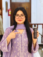 Woman in lavender holding Rootica Herbal Hair Oil 200ml