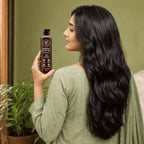 Pakistani woman with long thick hair holding Rootica Herbal Hair Oil 200ml